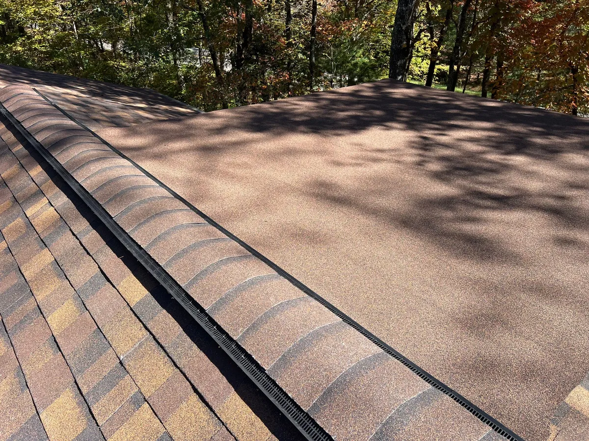 Cap shingles laid over a continuous ridge vent, two shingle planes running away on either side