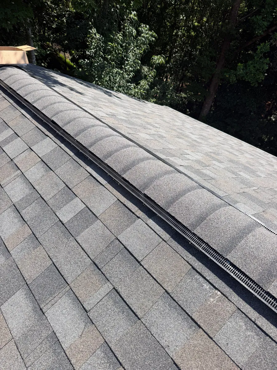 Cap shingles being set over a continuous ridge vent along the length of the ridge
